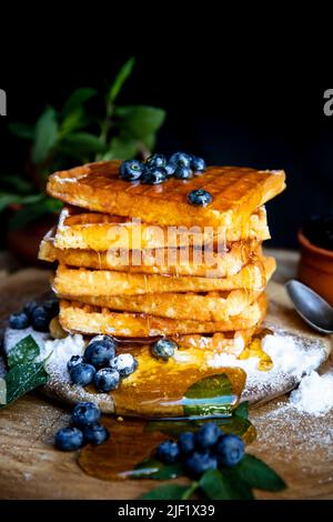 Waffles with fresh blueberries and honey on the rustic table. Freshly baked Belgian waffles Stock Photo