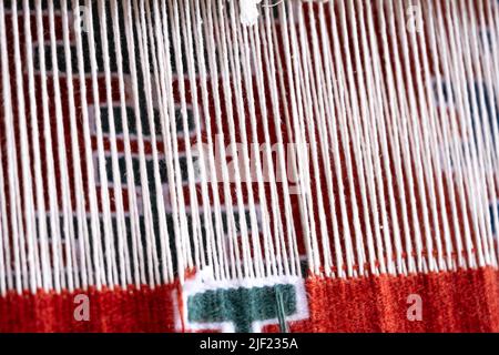 Close up, Detail of loom for weaving traditional handmade carpets, rugs.  Weaving and manufacturing of Turkish style homemade carpets. Selective focus Stock Photo