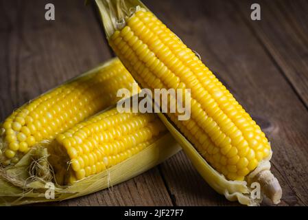 sweet corn cooked on wooden background, ripe corn cobs steamed or boiled sweetcorn for food vegan dinner or snack Stock Photo