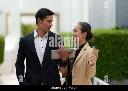 Portrait of Asian Senior Business woman and young business man discussing about Real Estate project. Stock Photo