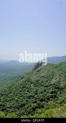 Beautiful landscapes of Ooty. Mountains with Green cover on rocks and Clear cloudy sky. Best place for family time and relaxation. Stock Photo