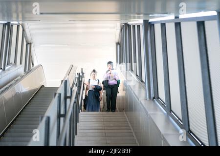 Group of young multi-racial female students laughing while going down the stairs. Stock Photo