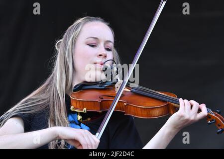 Fiddle player Bronwyn Keith-Hynes is shown performing on stage during a “live” concert appearance with Molly Tuttle and The Golden Highway at the Green River Festival. Stock Photo