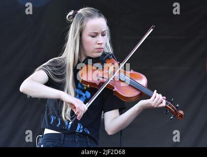 Fiddle player Bronwyn Keith-Hynes is shown performing on stage during a “live” concert appearance with Molly Tuttle and The Golden Highway at the Green River Festival. Stock Photo