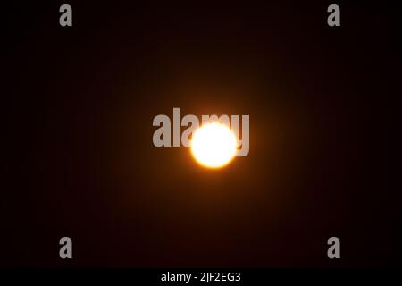 Bright blurred yellow spot. The sun on a black background. Stock Photo