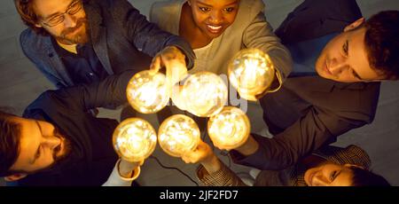 Creative business team with lightbulbs working together and developing creative ideas Stock Photo