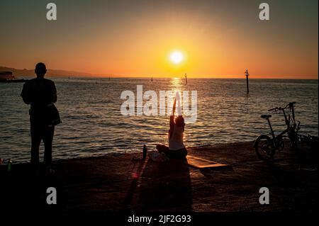 Barcelona, Spain: June 29, 2022,  A woman practises yoga as the sun rises over Mediterranean sea in Barcelona. Credit:  Jordi Boixareu/Alamy Live News Stock Photo