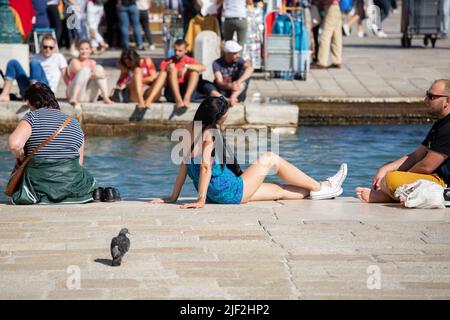 Venice –Italy, September 20 2015 young people relaxing in the hot mid day sun on the banks of the grand canal Venice Stock Photo