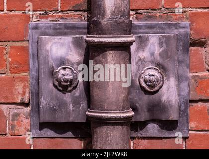 Ornate old fashioned lead down pipe and wall fixing for rain water Stock Photo