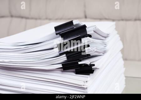 A stack of office papers, some of which are fastened with black binders Stock Photo
