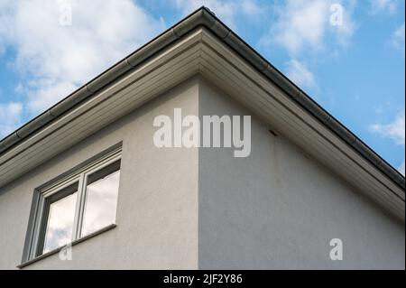 Upper floor of a white plastered house with roof box and double window Stock Photo