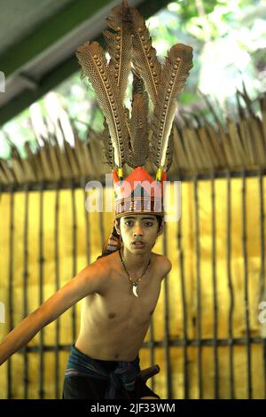Portrait of a tourism worker wearing indigenous attire during an indigenous dance performance for tourists at Mari Mari Cultural Village, a village that is designed to showcase the cultures of five ethnic groups of Sabah—a Malaysian state in North Borneo, which is located on the outskirts of Kota Kinabalu in Sabah, Malaysia. Stock Photo