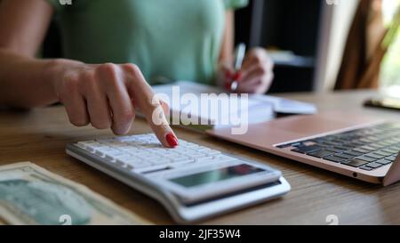 Woman hand using a calculator and letter makes note with cost calculation in home office Stock Photo