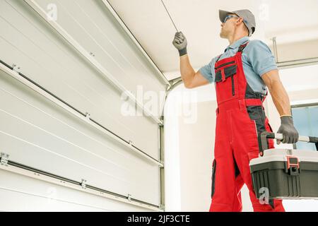 Modern Automatic Garage Doors Installation Performed by Professional Caucasian Installer. Residential Automation. Stock Photo