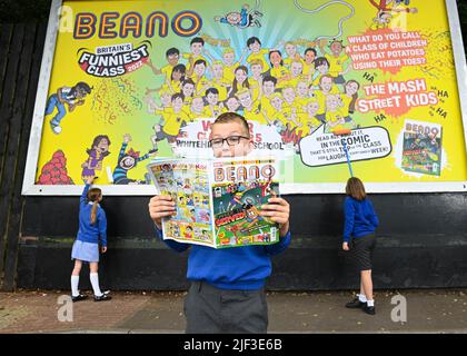 EDITORIAL USE ONLY Pupils from Voyager Year 5 class at Whitehill Junior School unveil a billboard illustrating their winning joke as they are presented with the Beano 'Britain's Funniest Class' trophy by the comic staff writer Danny Pearson, Hertfordshire. Picture date: Wednesday June 29, 2022. The class came up with the winning joke, 'What do you call a class of children who eat potatoes using their toes? - The Mash Street Kids!'. The competition was fierce this year with hilarious jokes coming in from across the nation and receiving over 190,000 votes by the public. The annual initiative, cr Stock Photo