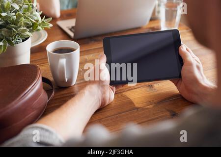 A man using his digital tablet while sitting at his table Stock Photo