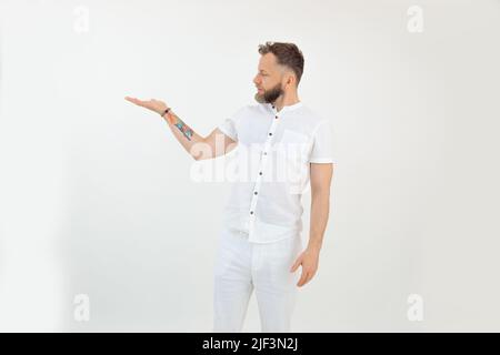 Handsome bearded confident, serious tattooed businessman in uniform on white backview. Showing place for text or product Stock Photo