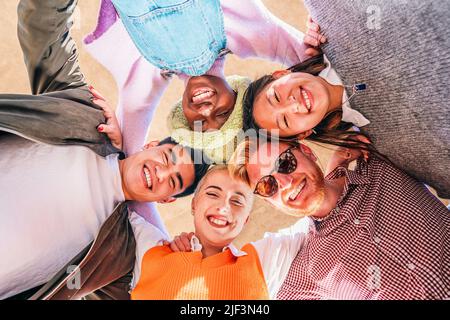 Portrait close up bottom view happy faces of diverse friends standing in circle, looking at camera,. down view photo Stock Photo