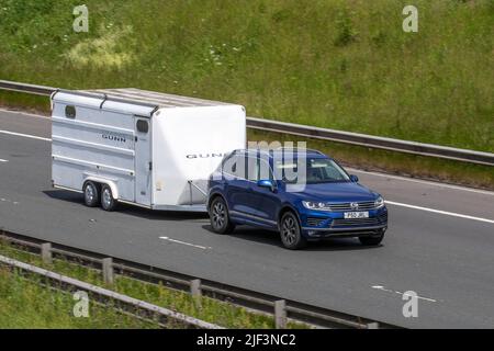 2016 blue VW Volkswagen Touareg V6 R-Line Tdi Bmt A V6 262 SCR 4Motion Bluemtion Diesel SUV towing Loaded GUNN two-wheeled large trailer Stock Photo