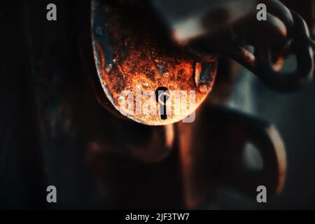 A large rusty old barn padlock with a chain closes the room. Safety. Tools. Stock Photo