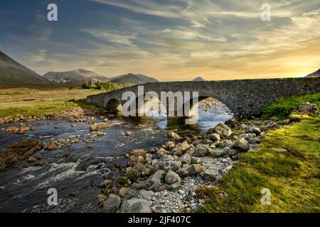 The Old Sligachan arched bridge on the Isle of Skye Scotland at sunset Stock Photo