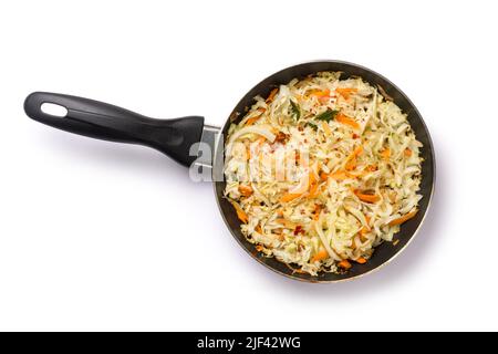 fresh healthy vegetable salad in a pan, cabbage and carrot mixed with olive oil and herbs, sprinkled mustard seeds, isolated on white background Stock Photo