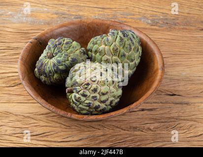 Sugar apples or custard apples in a bowl over wooden table. Stock Photo