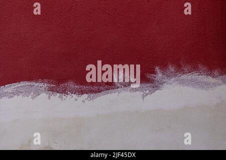 Maroon painted wall texture and half with white plaster plaster Stock Photo