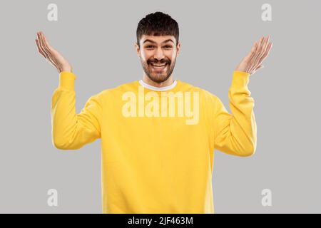 smiling young man in yellow sweatshirt Stock Photo
