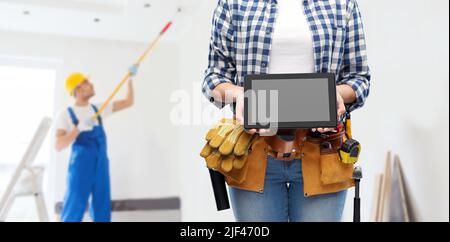 woman builder with working tools showing tablet pc Stock Photo