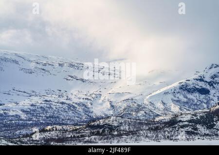 Winter landscape with high mountains with snow and sunny weather in april, Stora sjöfallet national park, Swedish Lapland, Sweden Stock Photo