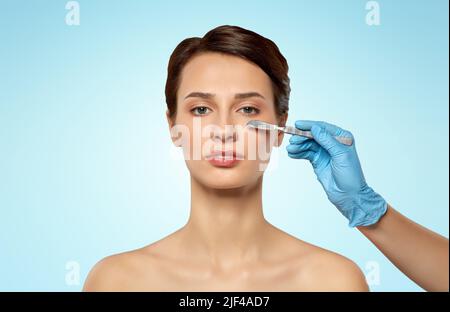 beautiful young woman and hand with scalpel Stock Photo