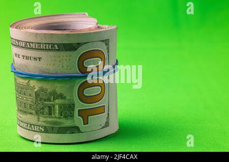 View of 100 dollar bills rolled into roll isolated on chrome key background. Sweden. Stock Photo