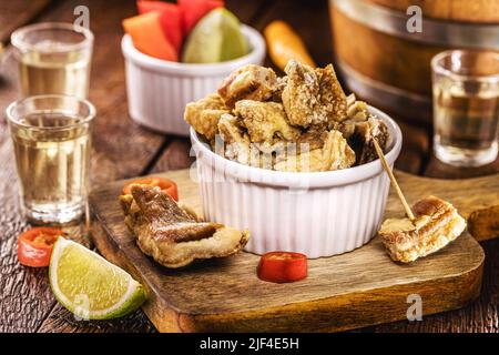 crispy fried pork rinds or bacon, served with cachaça or pinga, typical food from Minas Gerais Stock Photo