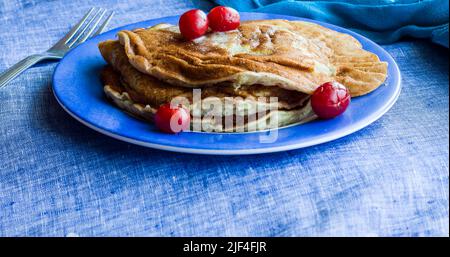 Straight on view of a stack of Banana Pancakes topped with cherries and melted butter. Healthy vegan breakfast concept.Close-up of pancakes. Stock Photo