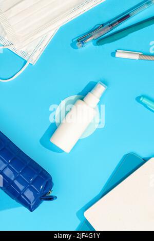 Spinning Hand Sanitizer and Stationery on Blue Table Stock Photo