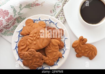 Top view of easter gingerbread cookies and cup of coffee on white background Stock Photo