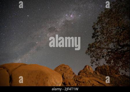 Milky Way shines over a mountain in the desert in Namibia Stock Photo