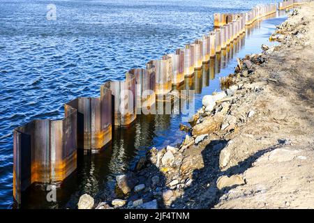 Temporary corrugated steel plate retaining wall during the strengthening and reconstruction of the river bank Stock Photo