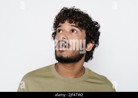 Young middle eastern man expressing surprise while looking upward isolated over white wall Stock Photo