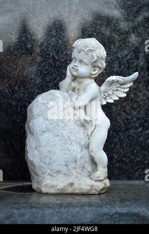 Little angel figurine on the grave Stock Photo