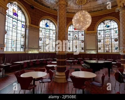 London, Greater London, England, June 15 2022: The Victoria and Albert Museum historic cafe with a lavish interior including stained glass windows. Stock Photo