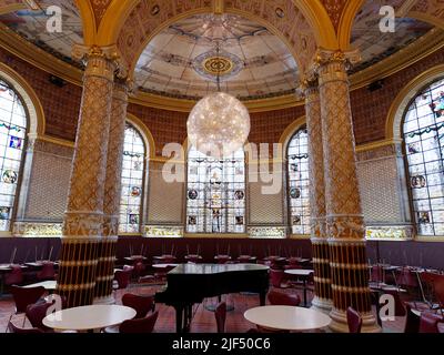 London, Greater London, England, June 15 2022: The Victoria and Albert Museum historic cafe with a lavish interior including stained glass windows. Stock Photo