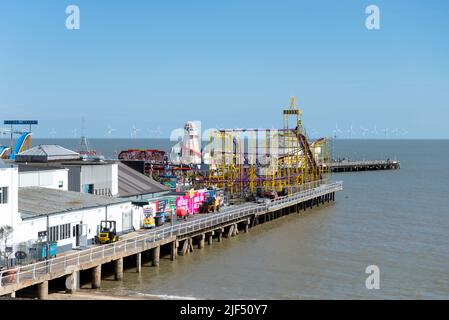 Clacton Pier, stretching out into the North Sea off Clacton on Sea, Essex, UK. Gunfleet Sands offshore wind farm on horizon Stock Photo