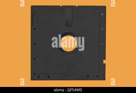Vintage Floppy Disk 5.25 inch. Retro storage technology isolated on orange background. Stock Photo