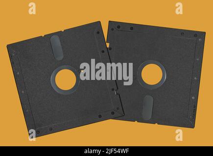 Vintage Floppy Disk 5.25 inch. Retro storage technology isolated on orange background. Stock Photo
