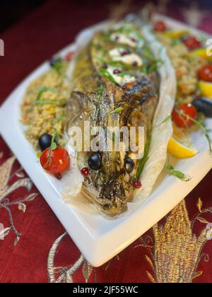 Baked stuffed pike perch with a side dish. fish dish in a restaurant Stock Photo