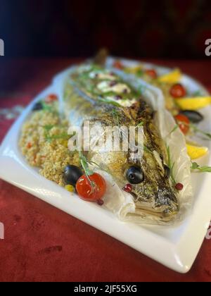 Baked stuffed pike perch with a side dish. fish dish in a restaurant Stock Photo