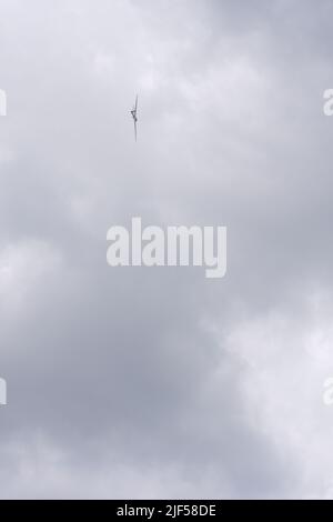 Glider flying high within dark clouds Stock Photo