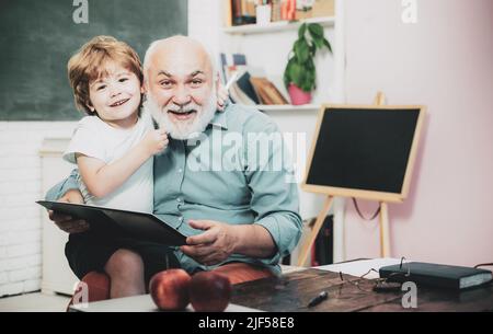 Learning and education concept. Teacher is skilled leader. Little ready to study. Grandfather and grandson. Concept of a retirement age. Educational Stock Photo